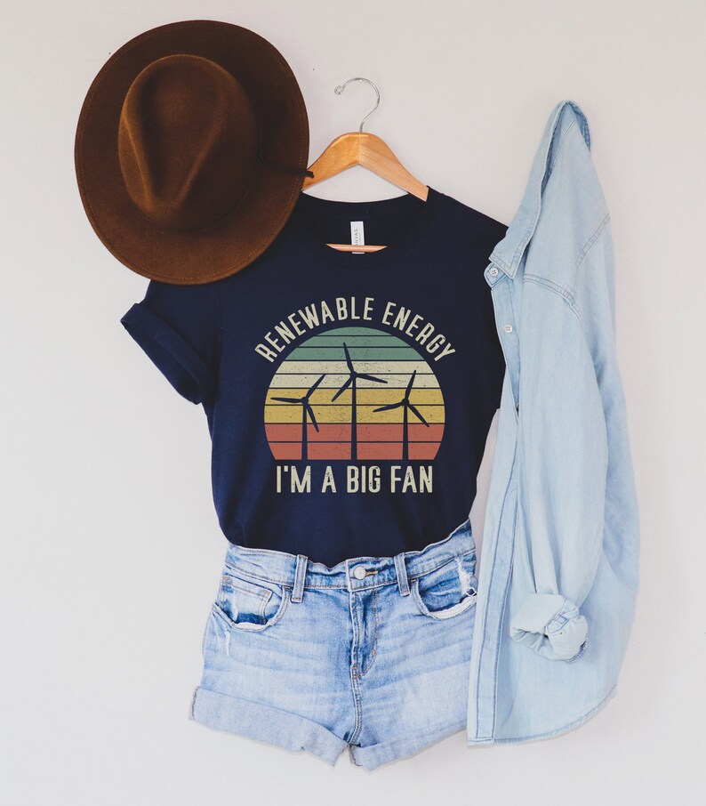 May include: A navy blue t-shirt with a vintage-style graphic of wind turbines and the text "Renewable Energy I'm a Big Fan".