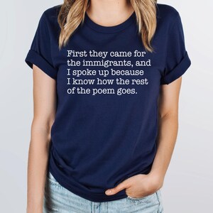 A navy blue unisex short sleeve crew neck t-shirt that says "First they came for the immigrants, and I spoke up because I know how the rest of the poem goes." in white typewriter font on the chest.