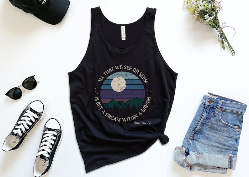Pu&ograve; includere: Canotta nera con una grafica in stile vintage di una luna, montagne e il testo "All that we see or seem is but a dream within a dream - Edgar Allan Poe".