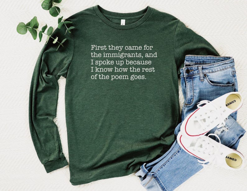 A heather forest green unisex long sleeve crew neck t-shirt that says "First they came for the immigrants, and I spoke up because I know how the rest of the poem goes." in white typewriter font on the chest.