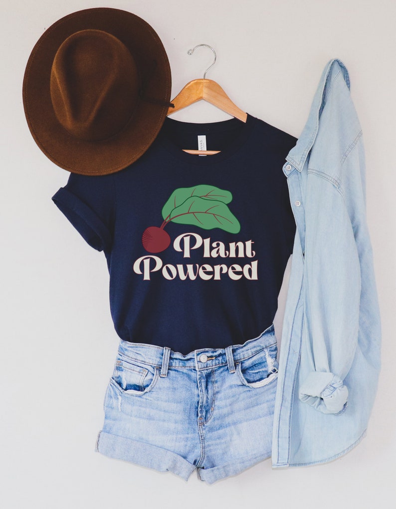 May include: A navy blue t-shirt with a green leaf and red beet graphic and the text "Plant Powered" in a retro font.