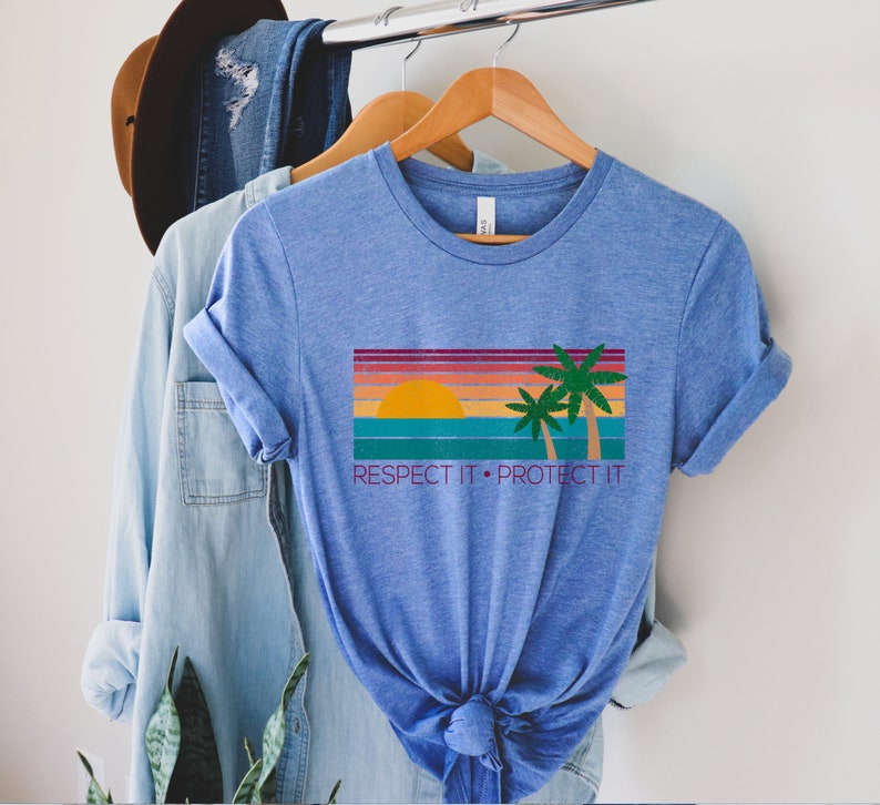 May include: A blue t-shirt with a retro sunset graphic and palm trees. The text "RESPECT IT. PROTECT IT" is printed below the graphic.