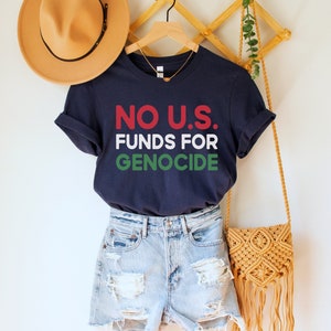 A navy blue unisex crew neck short sleeve t-shirt with red, white, and green text that says "No U.S. funds for genocide"