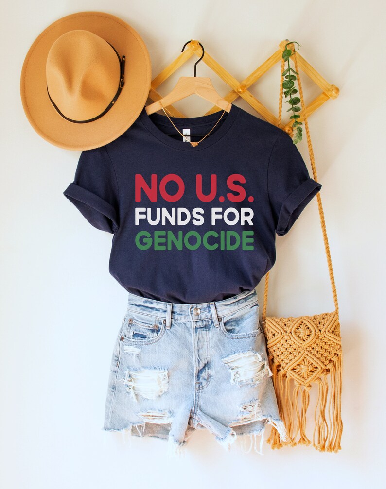 A navy blue unisex crew neck short sleeve t-shirt with red, white, and green text that says "No U.S. funds for genocide"