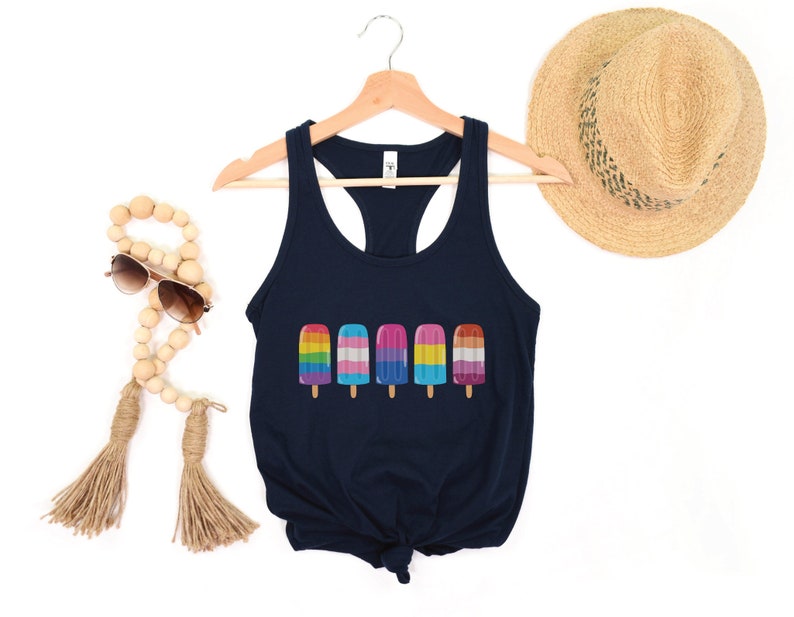 Pu&ograve; includere: Un top a canotta blu navy con un design di ghiaccioli con i colori dell'arcobaleno, della bandiera transgender e della bandiera bisessuale. Il top &egrave; su un appendiabiti e ha uno stile racerback.