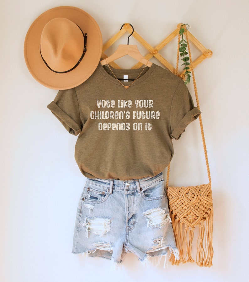 A heather olive green/brown unisex crew neck short sleeve Bella Canvas t-shirt that says "vote like your children's future depends on it" in white chalkboard font