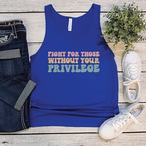 A royal blue unisex scoop neck Bella Canvas tank top that says "fight for those without your privilege" in peach, yellow, and green text with a white outline