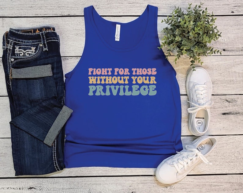A royal blue unisex scoop neck Bella Canvas tank top that says "fight for those without your privilege" in peach, yellow, and green text with a white outline