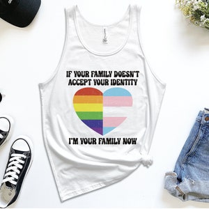 May include: White tank top with a rainbow and transgender pride flag heart design. The text reads "If your family doesn't accept your identity I'm your family now."