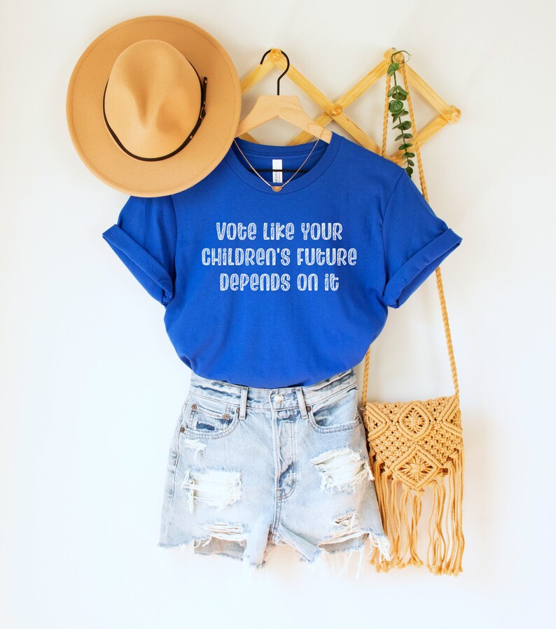 A royal blue unisex crew neck short sleeve Bella Canvas t-shirt that says "vote like your children's future depends on it" in white chalkboard font