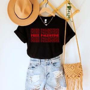 A black unisex crew neck t-shirt with red text saying "Free Palestine" 5 times, with the middle text full red and the top and bottom 2 just a red outline