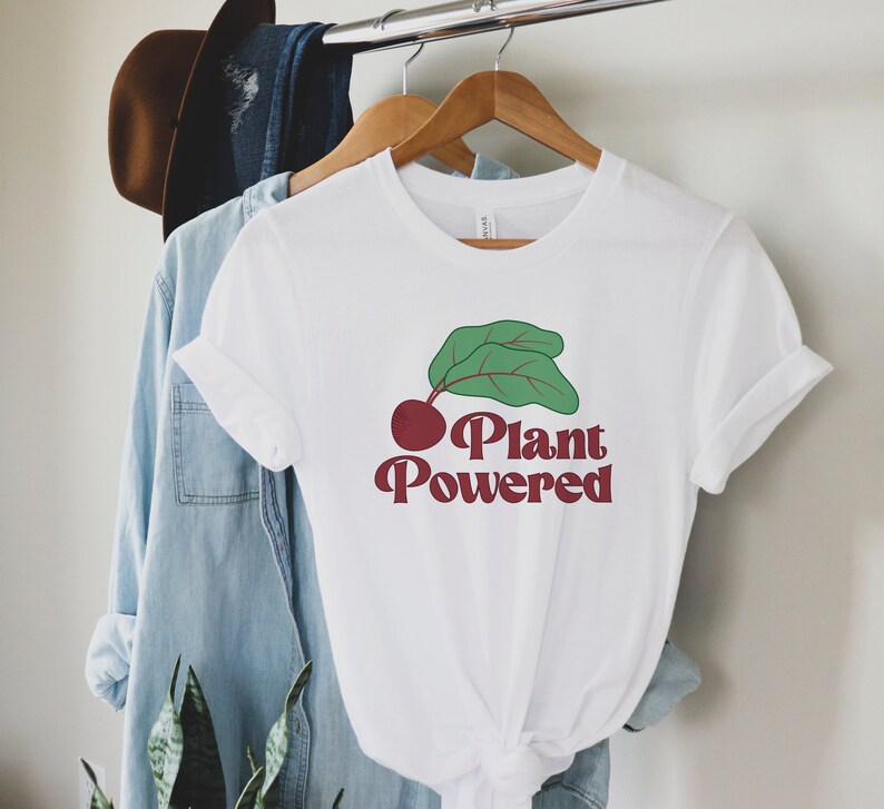 May include: White t-shirt with a red beet and green leaves graphic and the text "Plant Powered" in red.
