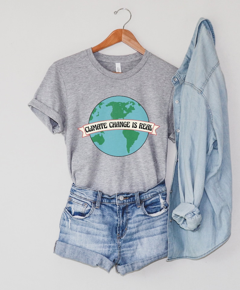 May include: Grey t-shirt with a blue and green globe graphic and the text "Climate Change is Real" in a banner.