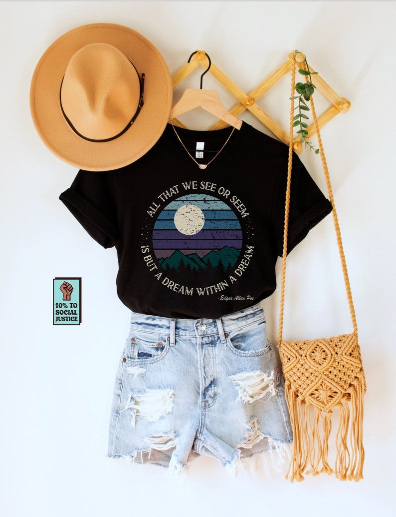 May include: Black t-shirt with a retro-style graphic featuring a moon, mountains, and the text "All that we see or seem is but a dream within a dream - Edgar Allan Poe".
