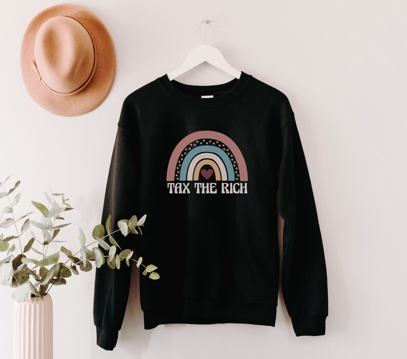 May include: Black sweatshirt with a rainbow graphic and the text "Tax the Rich" in white.