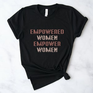 May include: Black t-shirt with the text "EMPOWERED WOMEN EMPOWER WOMEN" in a pink and white gradient.