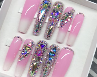 May include: Set of ten pink and white ombre press-on nails with iridescent rhinestones.