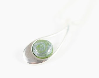 May include: A silver pendant necklace with a green and silver swirl glass bead.