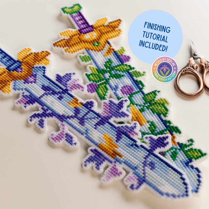 K&ouml;nnte beinhalten: Kreuzstich-Schwertdesigns mit floralen Akzenten in Blau-, Lila-, Gr&uuml;n- und Goldt&ouml;nen. Das Bild enth&auml;lt einen blauen Kreis mit dem Text "FINISHING TUTORIAL INCLUDED!" und ein Logo. Eine Schere ist ebenfalls zu sehen.