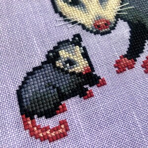 Closeup view of possum cross stitch pattern. This is a closeup of the baby sitting next to mama specifically. He is facing her. Even though he is much smaller than her, he is in the exact same pose (however mirrored). His tail is pink.