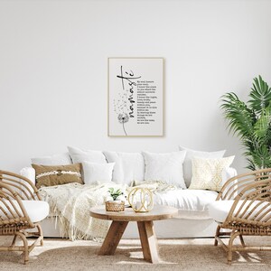 May include: A white couch with two chairs and a coffee table in a living room. A framed print with a dandelion and the word "namaste" is hanging on the wall. The print includes a poem about the soul and the universe.