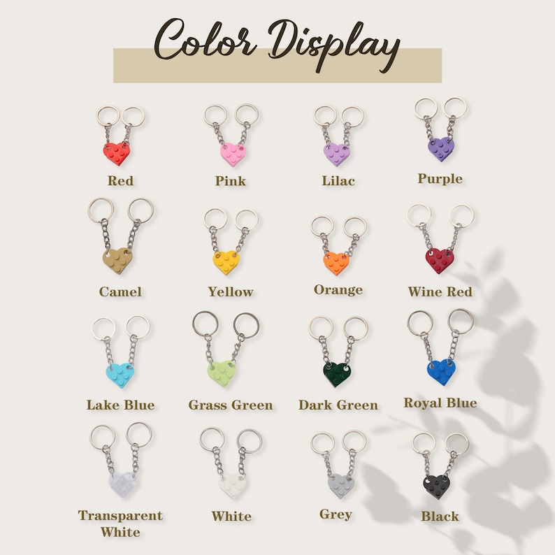 May include: Color display of 16 different keychain designs. Each keychain features two connected rings and a heart-shaped charm made of plastic LEGO bricks. The charms are available in a variety of colors, including red, pink, lilac, purple, camel, yellow, orange, wine red, lake blue, grass green, dark green, royal blue, transparent white, white, grey, and black.
