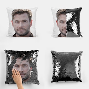 Puede incluir: Una almohada reversible de lentejuelas negras y blancas con una foto de la cara de un hombre en un lado. Las lentejuelas se pueden voltear para revelar un color negro sólido.