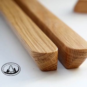 Pu&ograve; includere: Due pioli in legno con bordi arrotondati, realizzati in legno marrone chiaro con una venatura naturale. I pioli sono leggermente diversi in lunghezza e larghezza.
