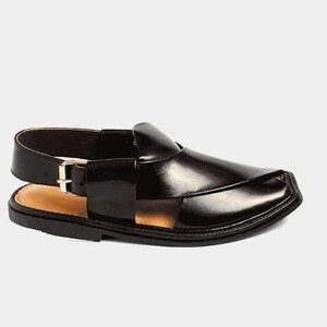 May include: Black leather sandal with a square toe and a strap that buckles at the ankle. The sandal has a woven design across the top and a light brown insole. The sole is black.