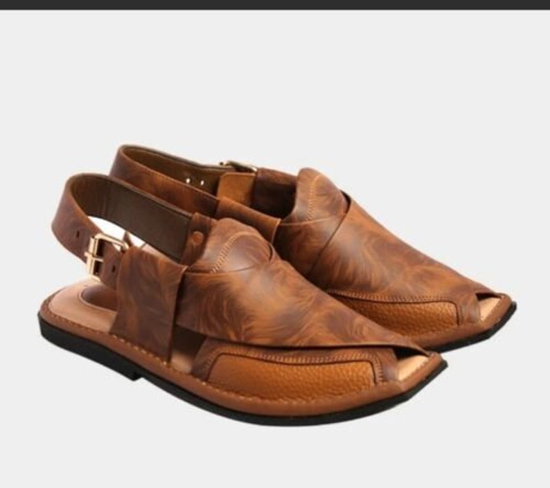 Puede incluir: Un par de sandalias de cuero marr&oacute;n con dise&ntilde;o de punta abierta. Las sandalias presentan una parte superior texturizada, correa de tobillo ajustable con hebilla dorada y suela negra. Dise&ntilde;adas para comodidad y estilo.