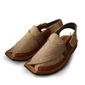 May include: Pair of tan and brown leather sandals with a woven fabric upper. The sandals have a square toe design and adjustable ankle straps. The soles are brown with visible stitching.
