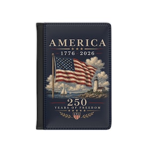 May include: A navy blue passport holder with the word "AMERICA" in gold lettering. The design includes an American flag, a lighthouse, and the text "1776-2026" and "250 YEARS OF FREEDOM".