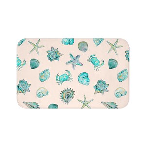 May include: A white ceramic mug with a black handle and the text "But First, Coffee" in a bold, black font. The mug is set against a neutral background, highlighting its simple design.