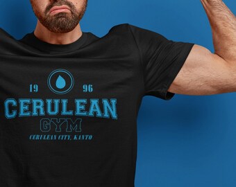 Puede incluir: Un hombre con una camiseta negra con un gráfico azul que dice "1996 Cerulean Gym Cerulean City, Kanto" y una gota de agua azul. Está flexionando los bíceps.
