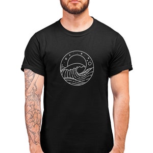 K&ouml;nnte beinhalten: Ein schwarzes T-Shirt mit einem wei&szlig;en Grafikdruck einer Welle, eines Mondes und Sternen in einem Kreis.