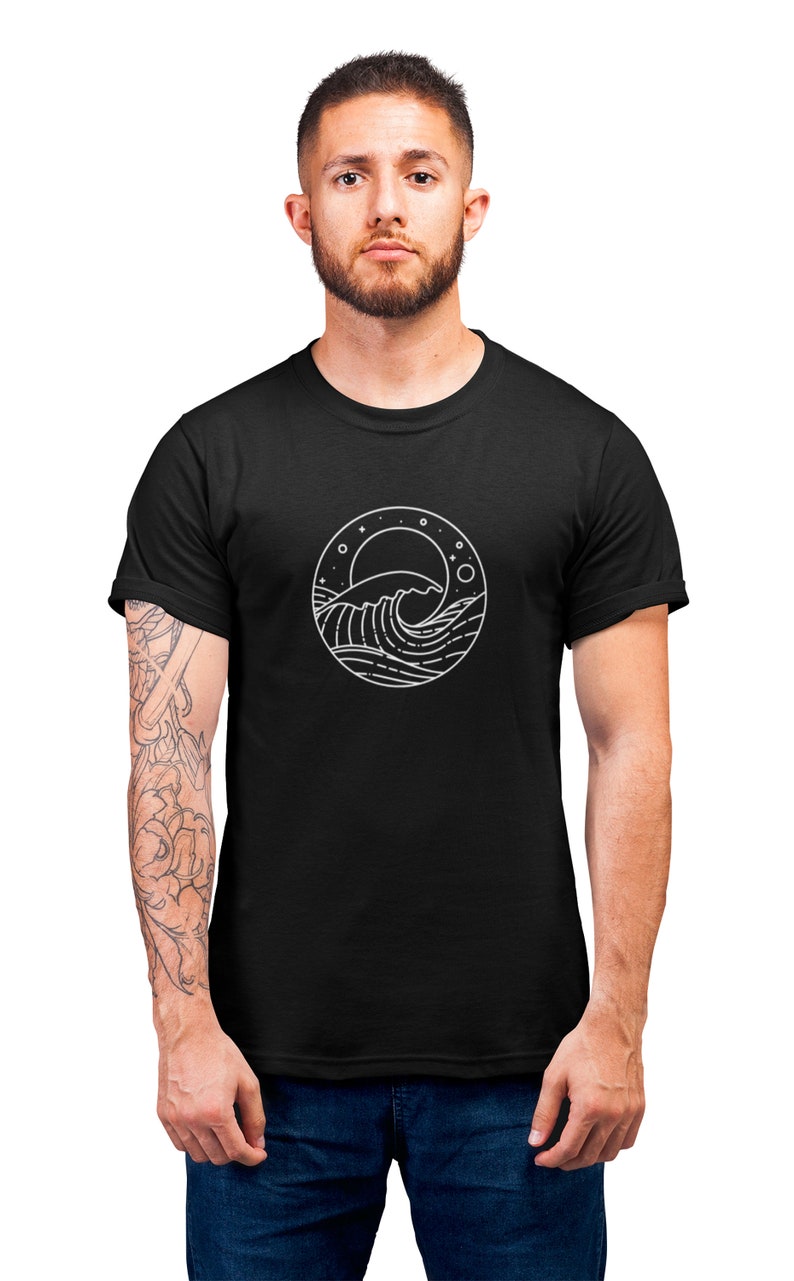 K&ouml;nnte beinhalten: Ein schwarzes T-Shirt mit einem wei&szlig;en Grafikdruck einer Welle, eines Mondes und Sternen in einem Kreis.