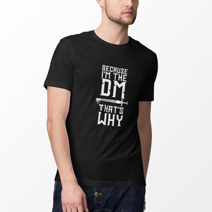 Puede incluir: Camiseta negra con texto blanco que dice "Because I'm the DM That's Why" con un gr&aacute;fico de espada.