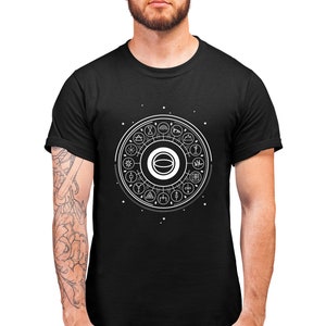 May include: A black t-shirt with a white graphic design of a circle with various symbols inside. The circle is surrounded by small white stars.