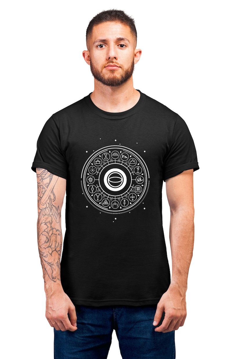 May include: A black t-shirt with a white graphic design of a circle with various symbols inside. The circle is surrounded by small white stars.