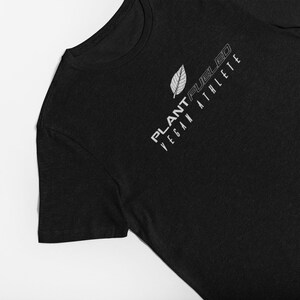 May include: Black t-shirt with a white leaf design and the text "PLANT-FUEL'D VEGAN ATHLETE" printed on the front.