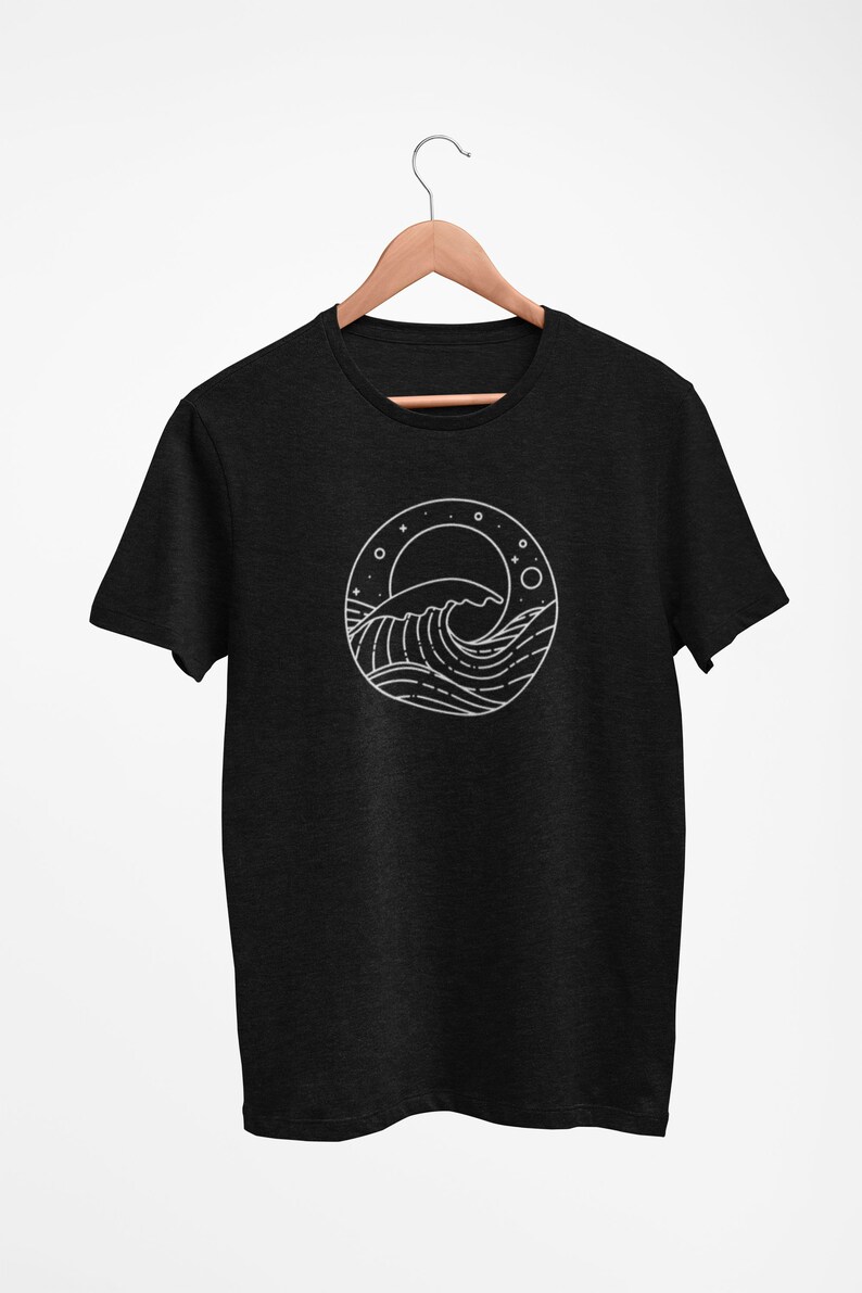 K&ouml;nnte beinhalten: Ein schwarzes T-Shirt mit einer wei&szlig;en Linienzeichnung einer Welle, eines Mondes und Sternen in einem Kreis.