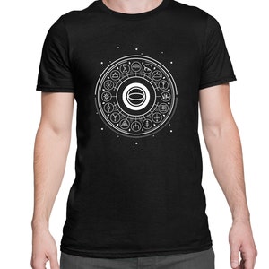 May include: A black t-shirt with a white graphic of a circle with various symbols and designs inside. The graphic is centered on the shirt.