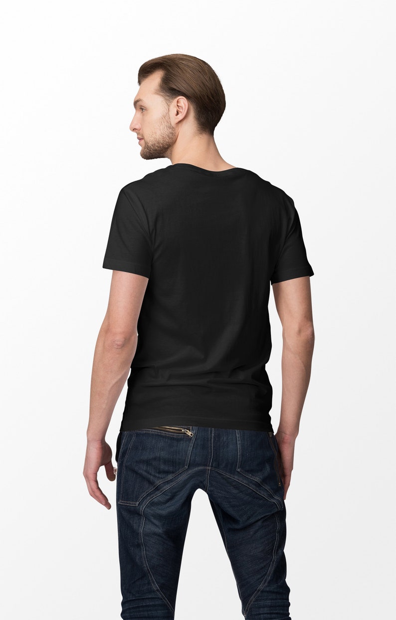 Pu&ograve; includere: Un uomo indossa una maglietta nera e jeans blu. I jeans hanno un dettaglio con cerniera sulla tasca posteriore.