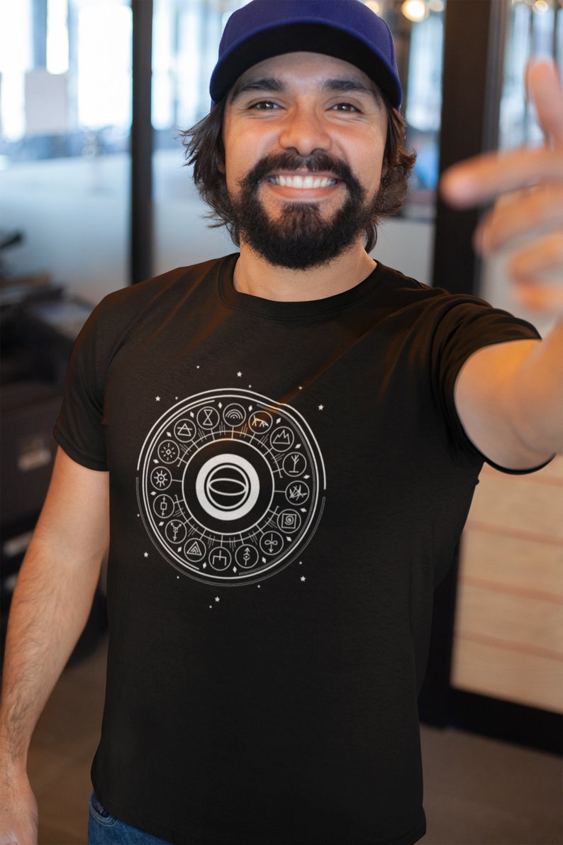 May include: A black t-shirt with a white graphic of a circle with symbols and a white ring in the center. The symbols include a sun, a moon, a mountain, a tree, a star, a wave, a lightning bolt, a heart, a hand, a flower, a bird, a fish, a snake, a spider, a skull, a cross, a triangle, a square, a circle, a line, a dot, and a spiral.