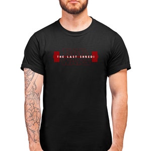May include: Black t-shirt with the text "THE LAST SHREDI WARS" in red. The design features a barbell graphic. The shirt is a crew neck and short-sleeved.