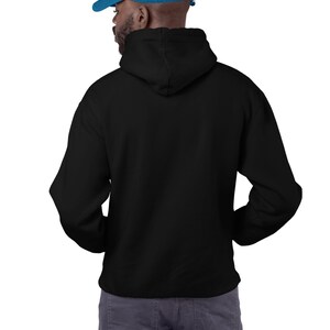 May include: A black hooded sweatshirt with a drawstring hood. The model is wearing a blue baseball cap.