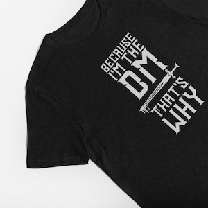 Puede incluir: Camiseta negra con texto blanco que dice "Because I'm the DM That's Why" con un gr&aacute;fico de espada.