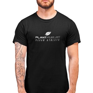 May include: A black t-shirt with a white graphic design that says "PLANT FUELED VEGAN ATHLETE" and a stylized leaf.
