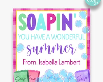 May include: A pink and white printable gift tag with the text "SOAPIN' YOU HAVE A WONDERFUL summer From, Isabella Lambert" and a cartoon image of soap bars and bubbles.