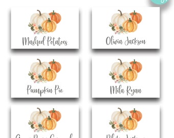 Op de afbeelding: Vier printbare Thanksgiving-tafelkaarten met aquarel-illustraties van pompoenen en herfstbladeren. De kaarten tonen de namen Olivia Jackson, Mila Ryan, Blake Jackson en de tekst "Gehakte aardappelen", "Pompoentaart" en "Groene bonen casserole".